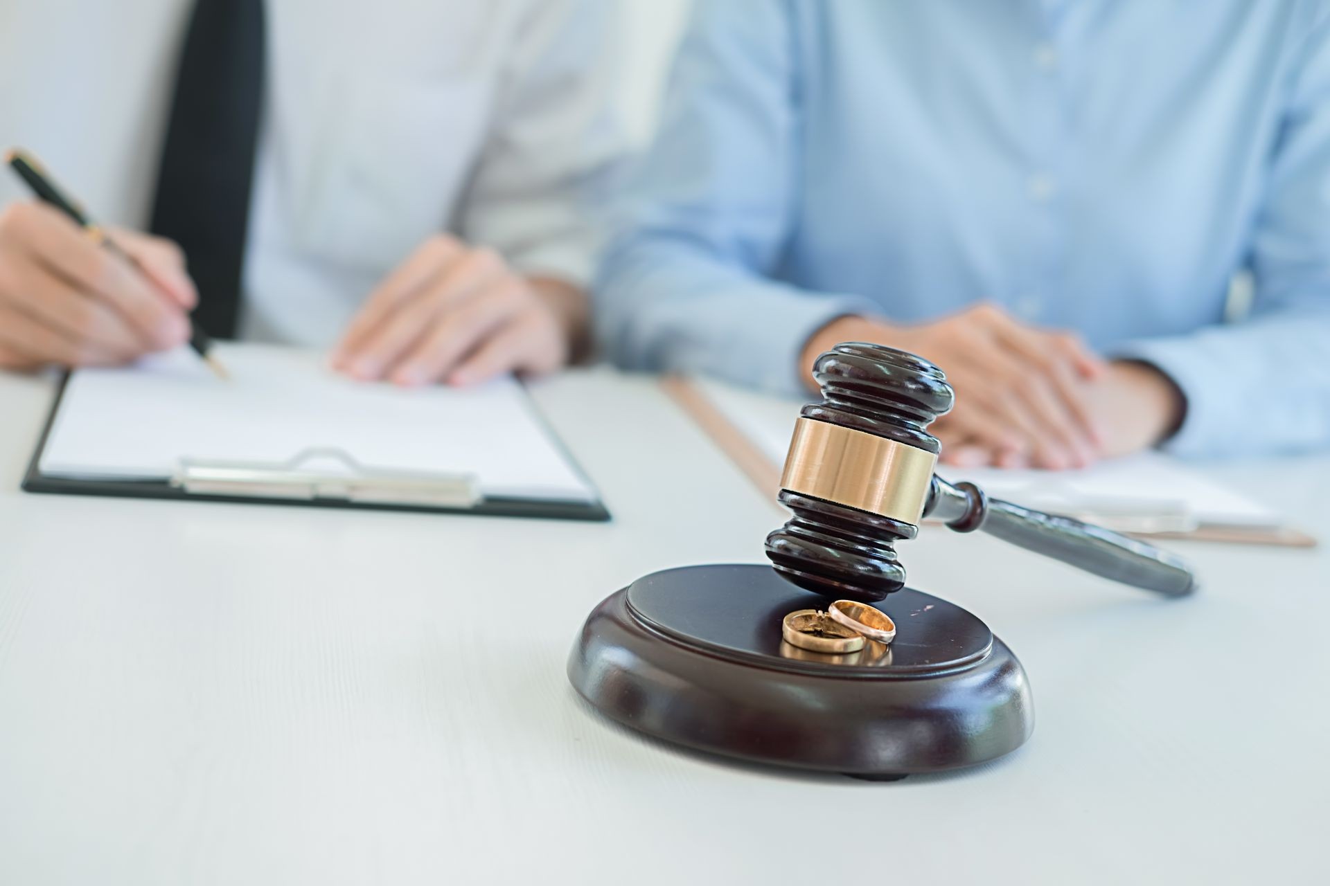 Judge gavel with Justice lawyers deciding, consultation on marriage divorce between married couple and signing divorce documents on table. Concepts of Law and Legal sevices.